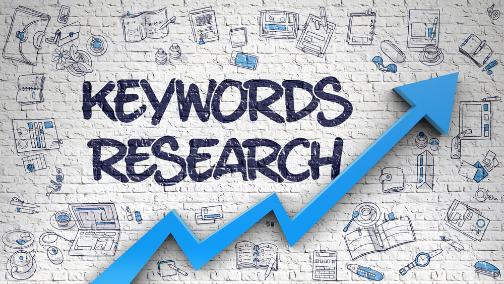 An illustration of the words 'Keywords Research' in graffiti style with a blue arrow pointing upwards on a brick wall background with various SEO and digital marketing related icons.