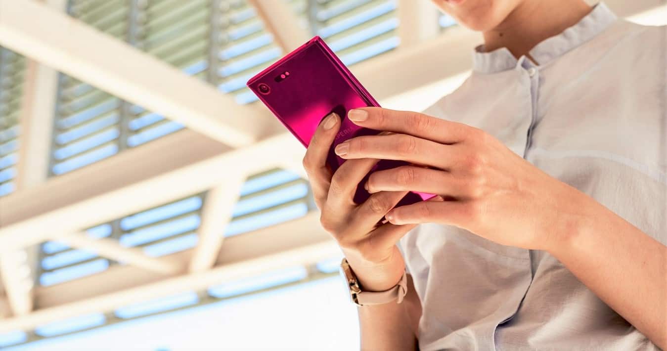 A person holding a pink phone in their hand, which represents the search query 'Transfer WhatsApp to new phone without verification'.