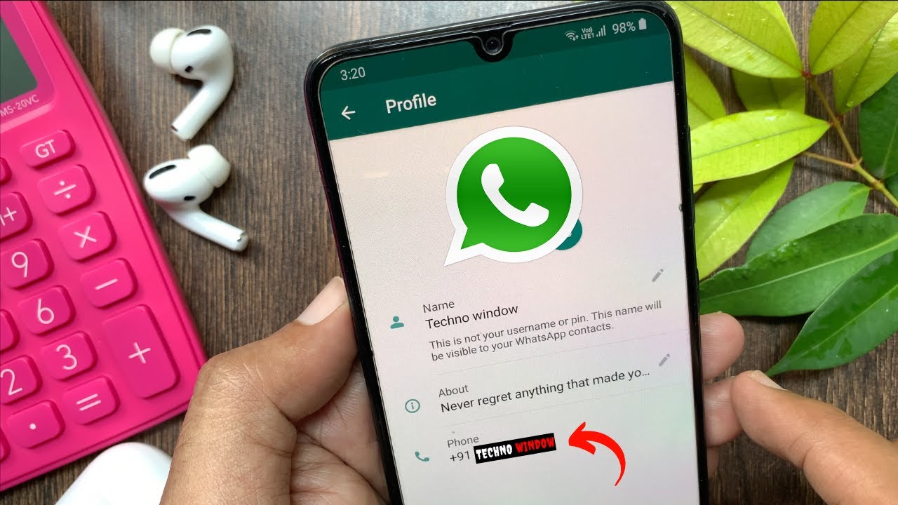 A hand holding a phone with the WhatsApp profile screen open and the 'Name' window highlighted, this window shows the name you are saved as in other people's WhatsApp contacts.