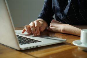 A person using a laptop to invest while traveling.