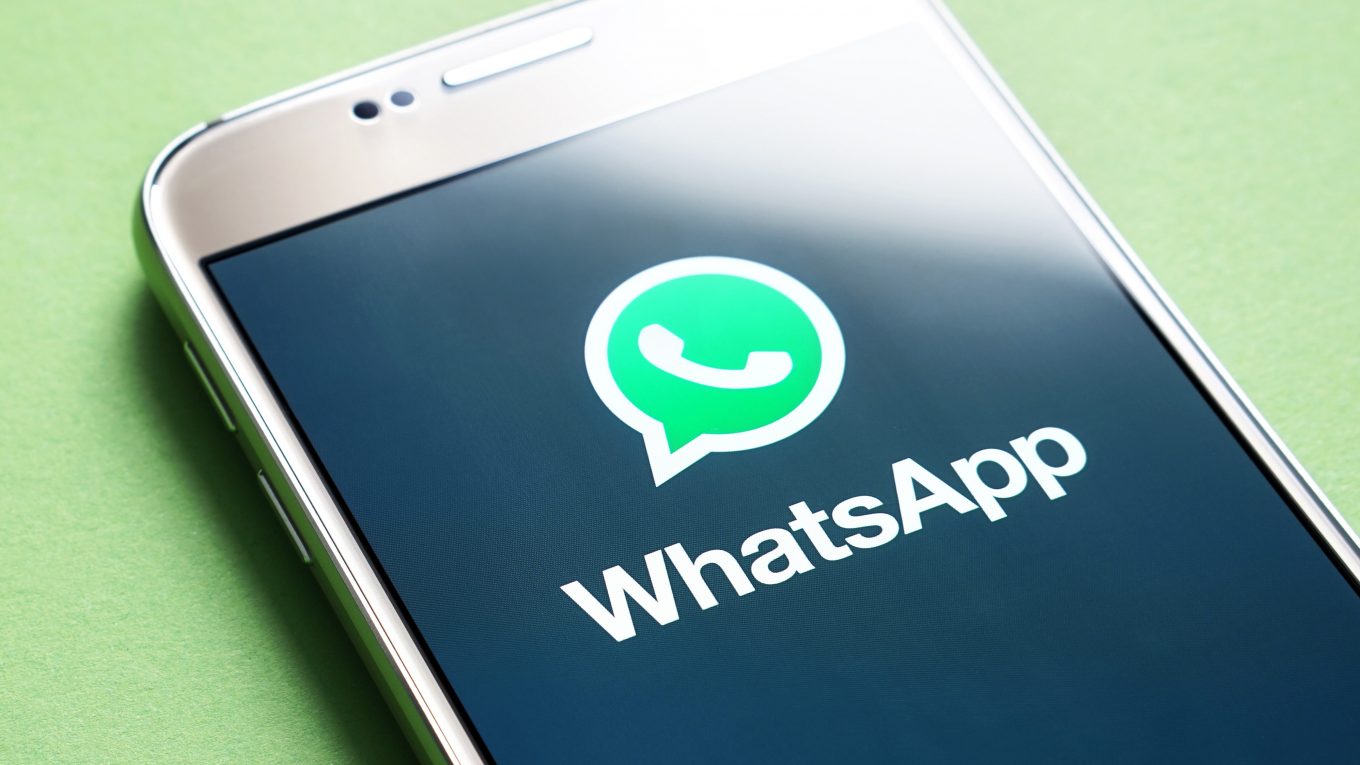 A screenshot of a smartphone with the WhatsApp logo on the screen, which is an app for sending and receiving text, video, and audio messages.