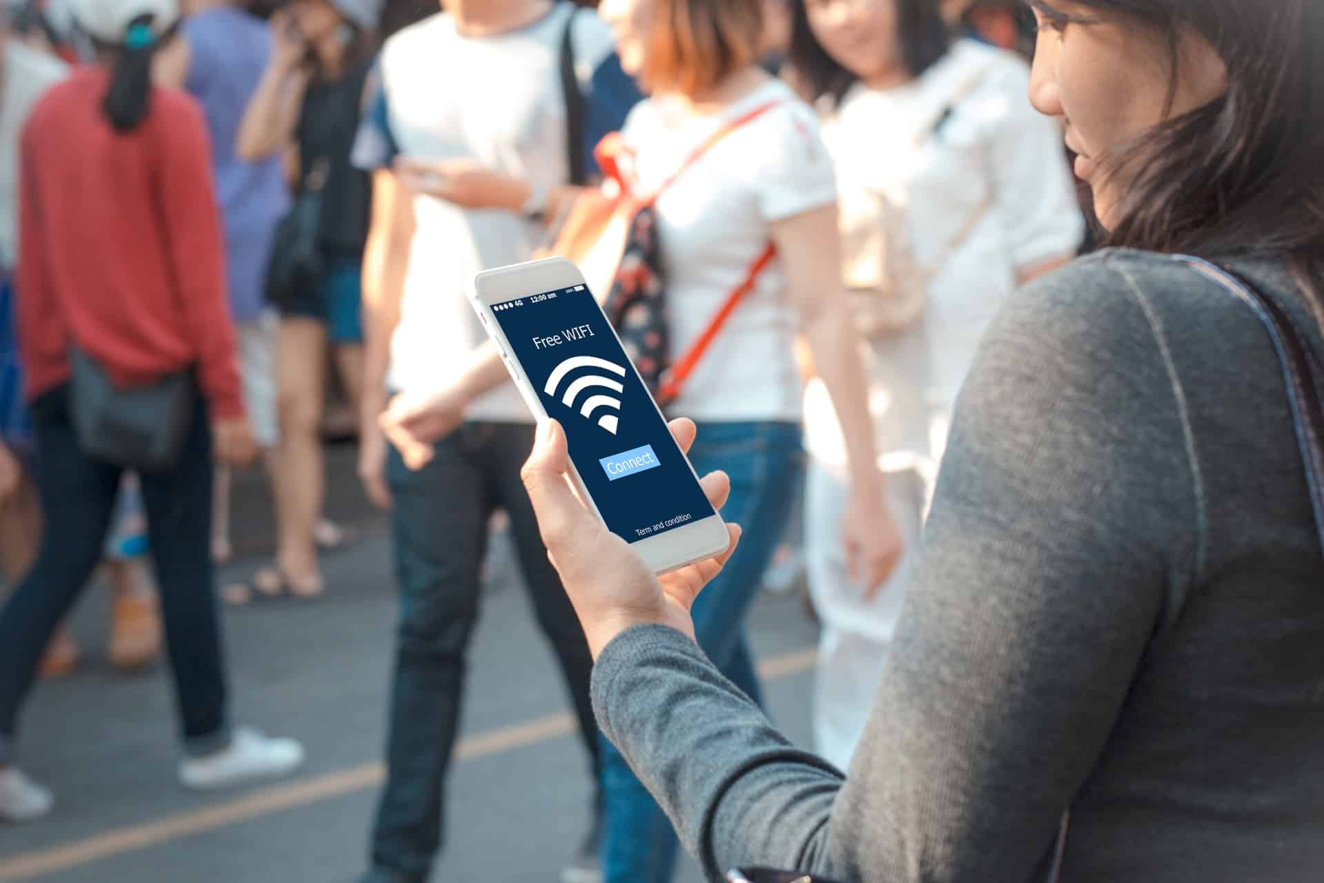 A woman is using her phone to connect to a secure public WiFi.