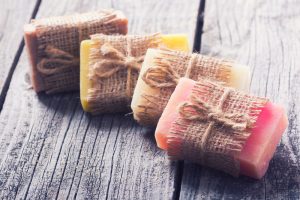 Artisanal soap wrapped in burlap on a wooden table.