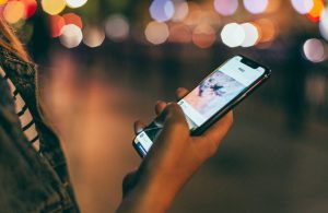 A person holds a mobile phone in their hand and uses a language learning app.