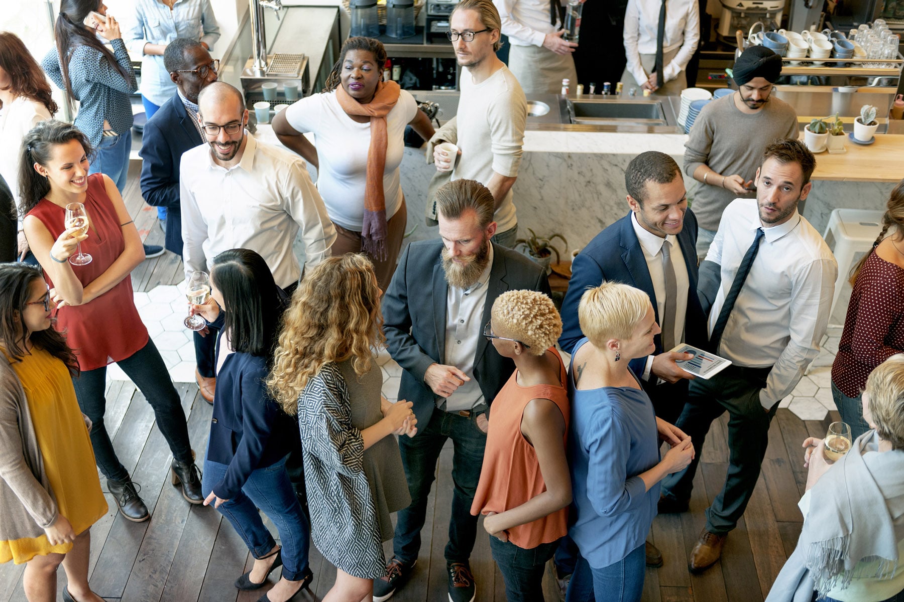 A group of diverse business professionals networking at a casual event.