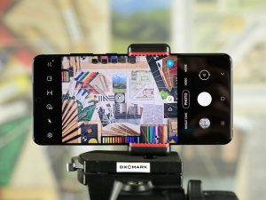 A smartphone with a high-resolution front camera is being used to take a picture of a still life arrangement.