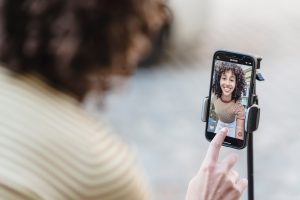 A person filming themselves on their phone to become a Facebook Pro Creator.