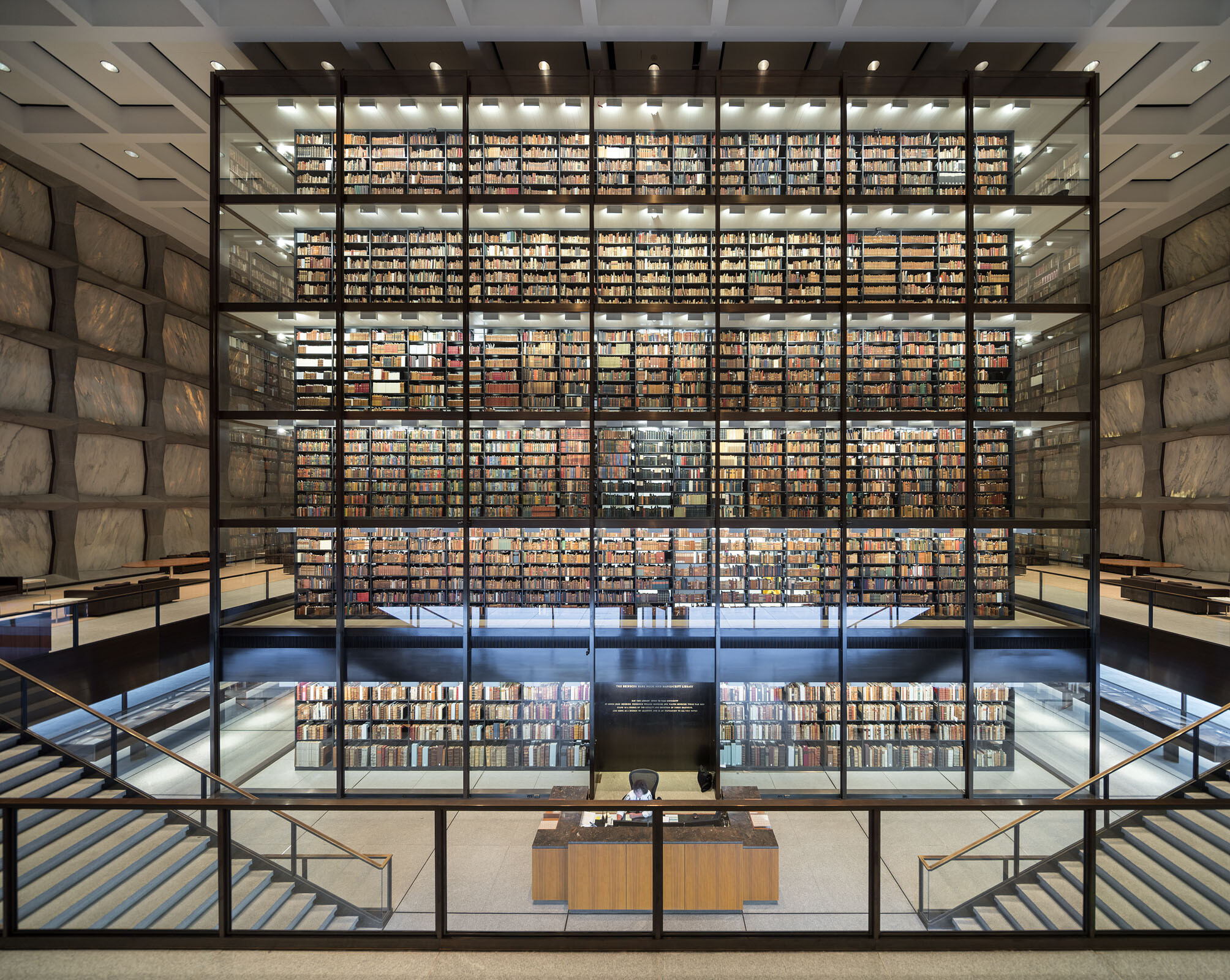 A large glass case filled with rare books in a library.
