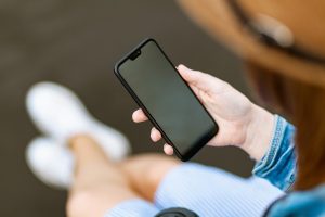 A person is holding a smartphone with a 'Blocked call' showing on the screen.