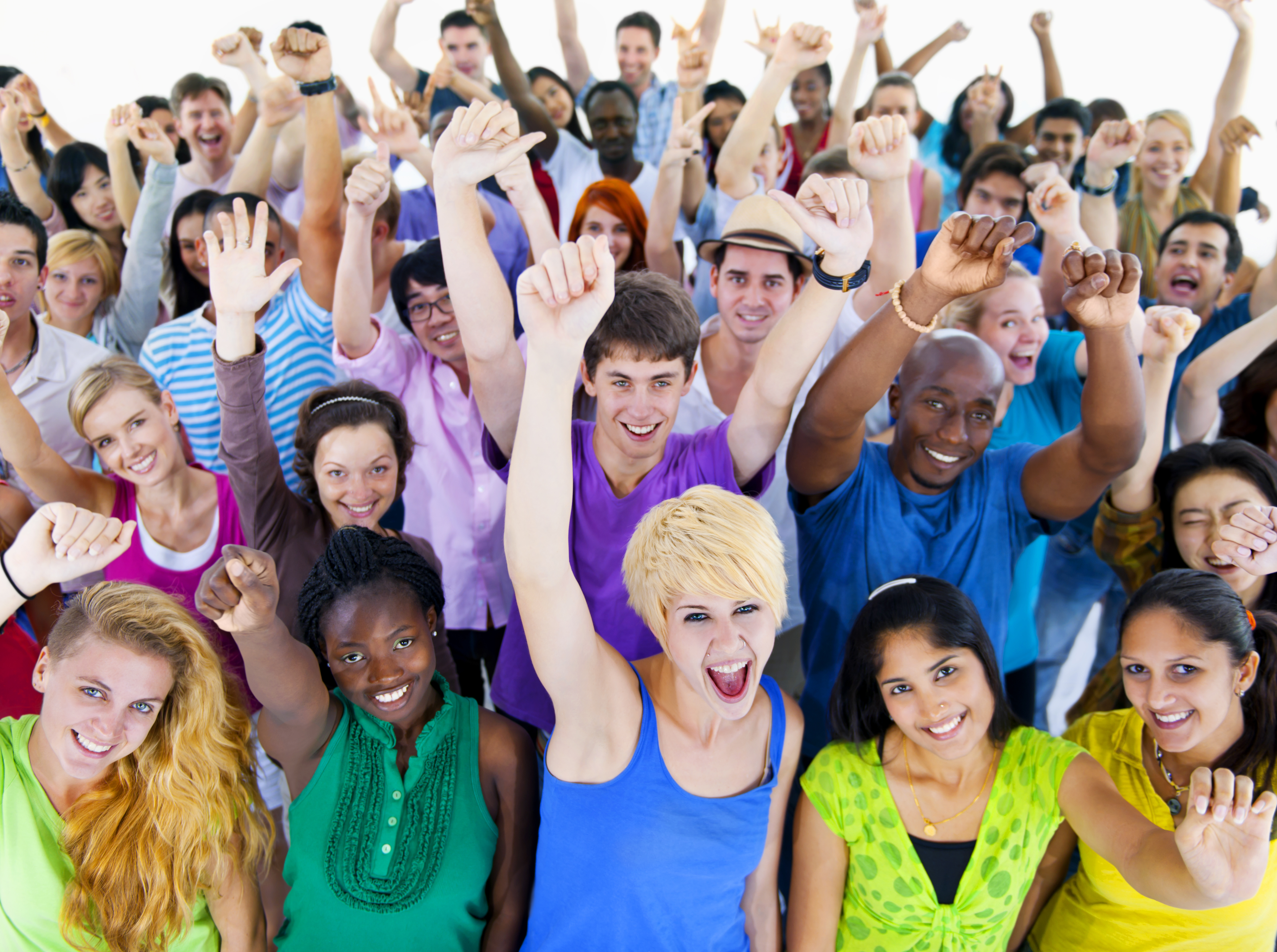 A large group of people from different cultures are celebrating together, with their hands raised in the air and joyful expressions on their faces.