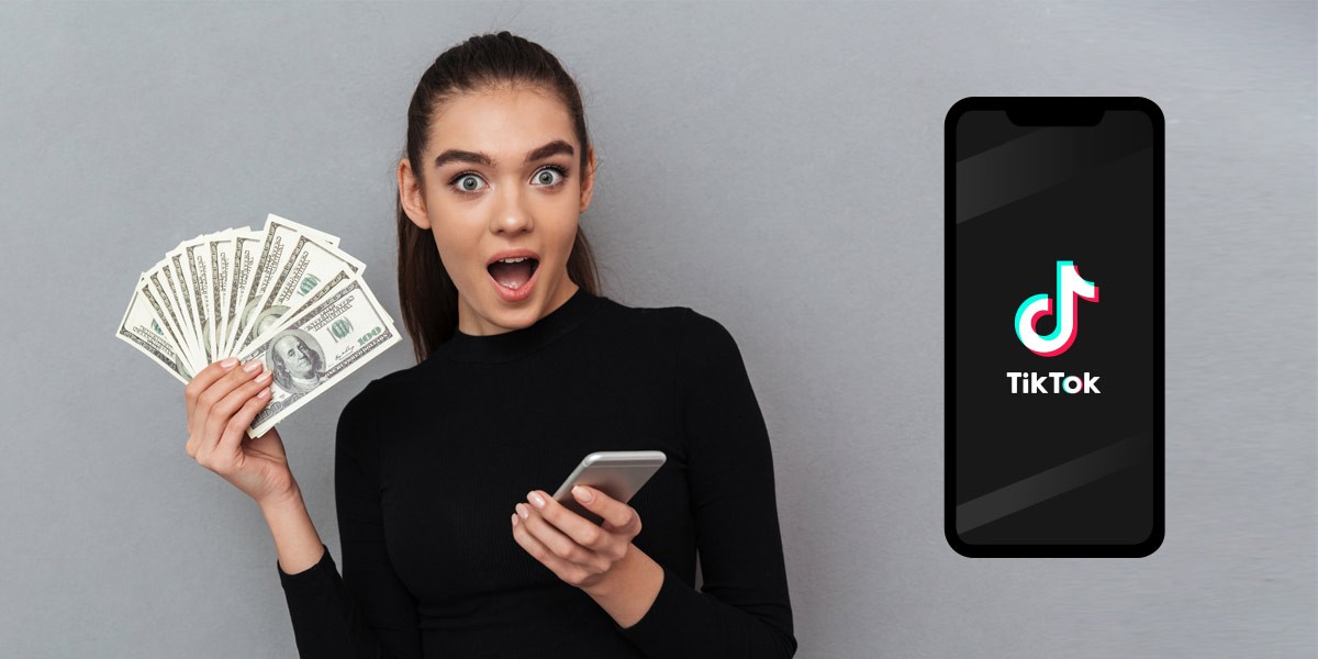 Image of a surprised young woman holding money next to her phone with the TikTok logo on the screen.
