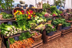 Local farmers harvesting and selling fresh produce at a farmers market.