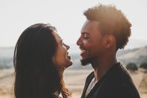 A man and a woman smile at each other with a bright background representing the search query 'Tips for safe and ethical online dating'.