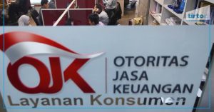 The image shows the lobby of the OJK office, where some employees are seen working in the background.