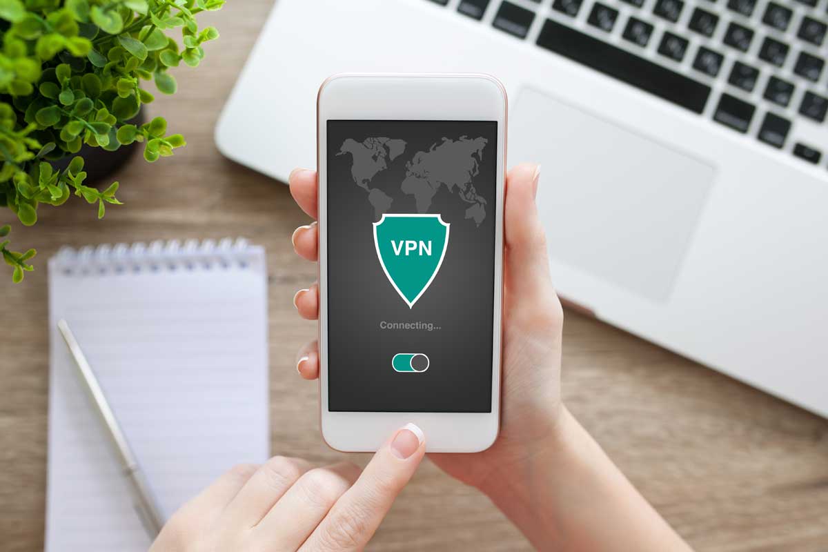 A hand holding a mobile phone with a VPN app on the screen.